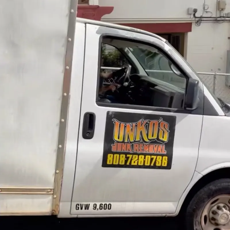 The white Unko's box truck with its orange door decal, driver at the wheel.